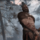 Kratos readies an axe to swing it at a tree in God of War on PC.